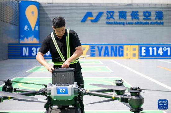 6月16日,在汉商低空港停机坪,一名工作人员给无人机更换电池。新华社记者 伍志尊 摄