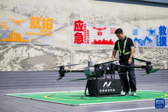 6月16日,在汉商低空港停机坪,一名工作人员在起飞前检查无人机工作状态。新华社记者 伍志尊 摄